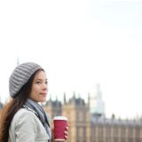 ビッグベンの前でコーヒーをもって佇む女性